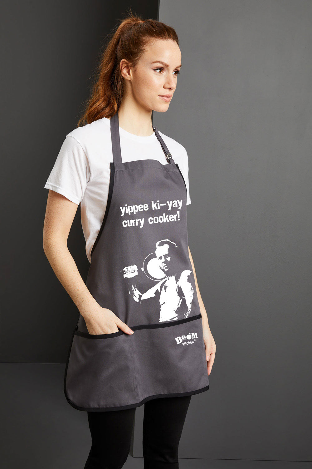 Yippee ki-yay Curry Cooker! Bruce Willis Charcoal Coloured Apron with Boom Kitchen logo Full length